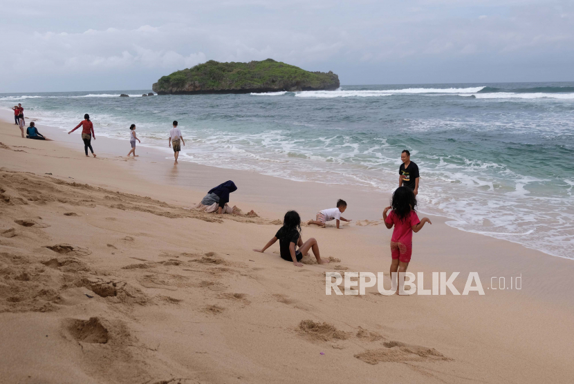 Wisatawan di Gunung Kidul Diingatkan Gelombang Tinggi. Wisatawan bermain di pantai Sadranan Dusun Pulegundes, Sidoharjo, Tepus, Gunungkidul, DI Yogyakarta.