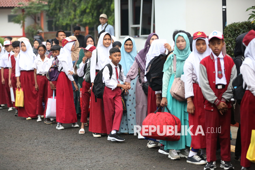 Para siswa dan orang tuanya mengantri sebelum mengikuti Sekolah Rakyat Tahun ajaran 2025/2026 di Sekolah Rakyat Sentra Terpadu Inten Soeweno, Kabupaten Bogor, Jawa Barat, Senin (14/7/2025).