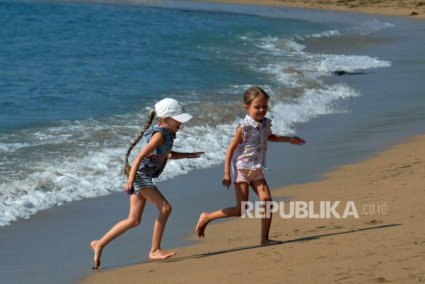 Dua anak turis menikmati suasana saat mengunjungi di Pantai Sindhu, Sanur, Denpasar, Bali, Rabu (9/6).