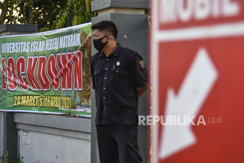 Seorang Satpam berjaga di depan pintu gerbang masuk ke kawasan kampus Universitas Islam Negeri (UIN) Mataram, NTB, Rabu (24/3/2021). 