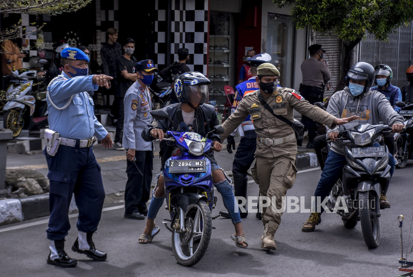 Petugas gabungan menghentikan pengendara yang tidak menggunakan masker saat operasi gabungan patroli pengawasan dan penegakan disiplin protokol kesehatan Covid-19 di Jalan Dalem Kaum, Kota Bandung Jawa Barat