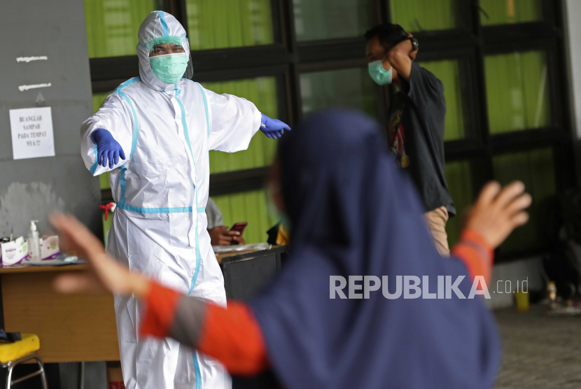  Seorang petugas kesehatan dengan pakaian pelindung melakukan latihan dengan pasien COVID-19 di Stadion Patriot Candrabhaga yang diubah menjadi pusat isolasi di Bekasi, pinggiran Jakarta, Indonesia, Rabu, 6 Januari 2021.