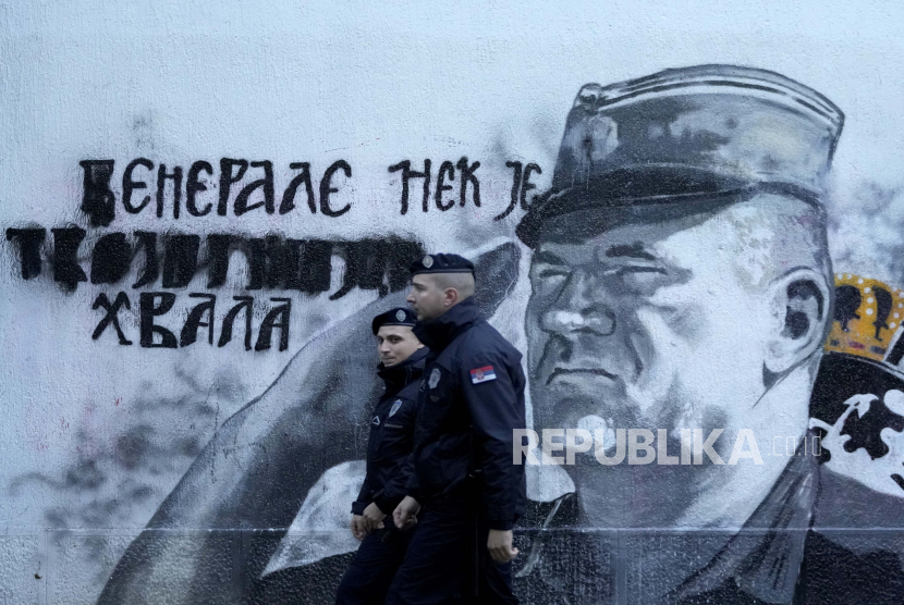  Petugas polisi berjalan di dekat lukisan dinding mantan kepala militer Serbia Bosnia Ratko Mladic di Beograd, Serbia, Selasa, 9 November 2021. Jerman sebut seruan agar bagian-bagian Bosnia memisahkan diri tidak bertanggung jawab. Ilustrasi.