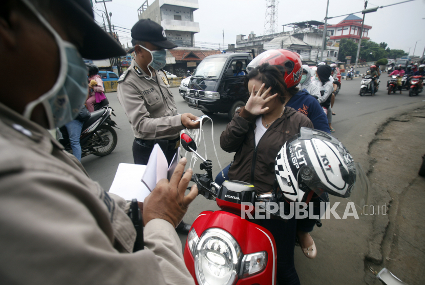 Petugas gabungan menindak pengendara motor yang tidak memakai masker di titik pemeriksaan penerapan Pembatasan Sosial Berskala Besar (PSBB), Cibinong, Bogor, Jawa Barat (ilustrasi)