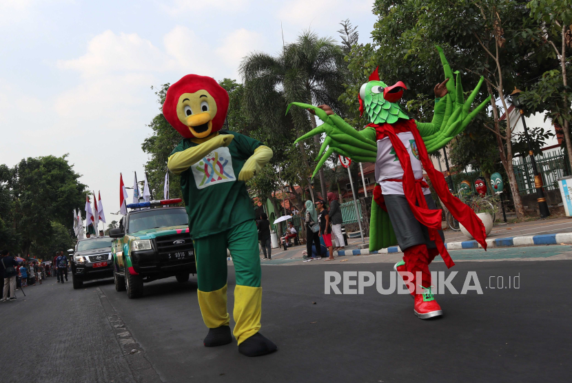 Maskot Pekan Olahraga Provinsi Jawa Timur (Porprov Jatim) VII 2023 menyapa masyarakat saat kirab obor api di Kabupaten Jombang, Jawa Timur.