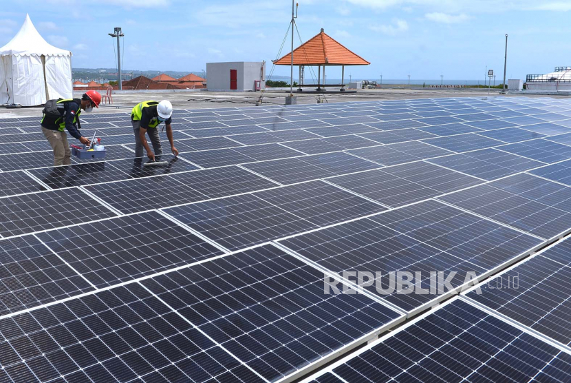 Petugas melakukan perawatan panel surya pada Pembangkit Listrik Tenaga Surya (PLTS) di Bandara I Gusti Ngurah Rai, Badung, Bali. ilustrasi
