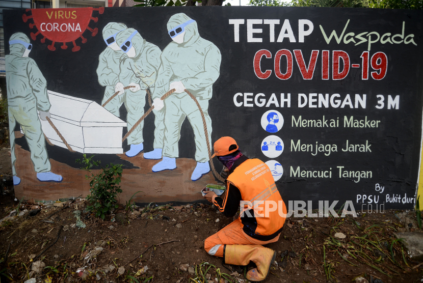 Petugas PPSU Kelurahan Bukit Duri, Jakarta menyelesaikan pembuatan mural tentang Covid-19, Jakarta, Senin (10/8). 
