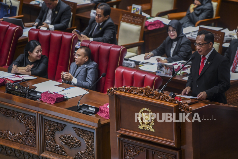 Menteri Dalam Negeri Tito Karnavian (kanan) menyampaikan pandangan pemerintah disaksikan Ketua DPR Puan Maharani (kiri) dan Wakil Ketua DPR Sufmi Dasco Ahmad (tengah) saat rapat paripurna DPR ke-14 masa persidangan IV tahun sidang 2023-2024 di kompleks Parlemen, Jakarta, Kamis (28/3/2024). Dalam rapat paripurna tersebut DPR mengesahkan revisi Undang-Undang (RUU) nomor 6 tahun 2014 tentang Desa menjadi Undang-Undang dengan demikian jabatan Kepala Desa menjadi delapan tahun dengan maksimal dua periode, selain itu DPR juga mengesahkan Rancangan Undang-Undang tentang Daerah Khusus Jakarta (RUU DKJ) sebagai Undang-Undang sehingga Jakarta tidak lagi menjadi Ibu Kota Negara atau DKI. 