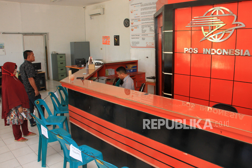 Petugas melayani pelanggan di Kantor Pos Meulaboh, Aceh Barat, Aceh, Senin (20/4/2020). Petugas PT POS mengaku, sejak sebulan terakhir pengiriman paket antar daerah rata-rata mengalami penurunan 7 sampai 10 persen per hari akibat dampak dari merebaknya wabah COVID-19