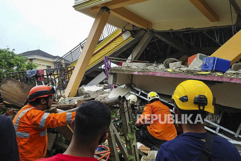 Gambar selebaran yang disediakan oleh Badan Pencarian dan Penyelamatan Nasional Indonesia (BASARNAS) menunjukkan penyelamat mencari korban di bawah reruntuhan bangunan yang runtuh setelah gempa berkekuatan 6,2 di Mamuju, Sulawesi Barat, Indonesia, 15 Januari 2021. Setidaknya tiga orang tewas dan puluhan luka-luka.