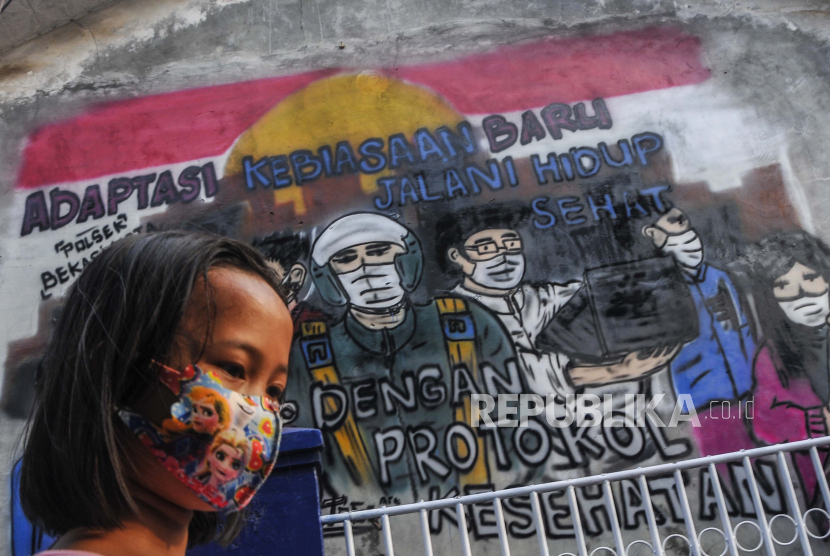 Seorang anak melintas di dekat mural sosialisasi untuk hidup sehat di Rawa Pasung, Bekasi, Jawa Barat, Jumat (7/8). Klaster keluarga disebut @pandemictalks paling banyak muncul di Bekasi. (ilustrasi)