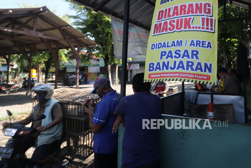 Pedagang keluar dari kawasan pasar saat pengosongan pasar Banjaran, di Kota Kediri, Jawa Timur. Pemerintah daerah setempat menutup pasar tradisional itu selama tiga hari pasca seorang pedagang dinyatakan positif COVID-19