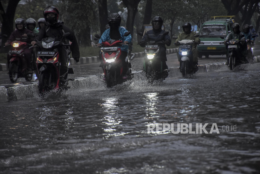 Pengendara melintasi genangan banjir di kawasan Gedebage, Bandung, Jawa Barat, Jumat (1/12/2023). Kawasan tersebut kerap dilanda banjir akibat drainase yang buruk saat intensitas curah hujan yang tinggi. Genangan banjir tersebut mengganggu akses lalu lintas dan merendam sebagian kawasan Pasar Gedebage.