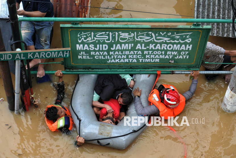 Petugas mengevakuasi warga saat banjir di Rawajati, Jakarta, Selasa (4/3/2025). Berdasarkan data BPBD DKI Jakarta mencatat, sebanyak 59 RT di kawasan Rawajati dan Cililitan terendam banjir dengan ketinggian mulai dari 30-300 centimeter yang disebabkan oleh meluapnya kali Ciliwung.