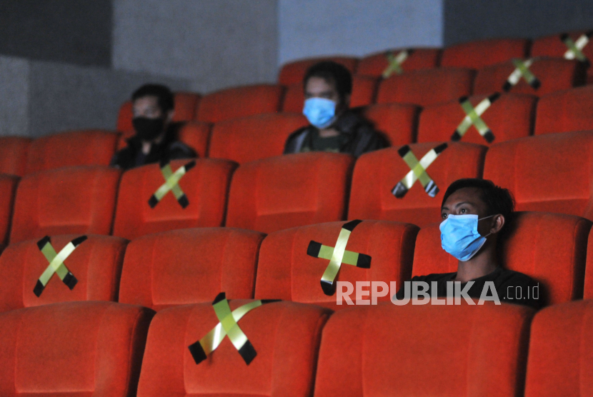 Pengunjung menyaksikan film di bioskop pada masa pandemi. Ilustrasi