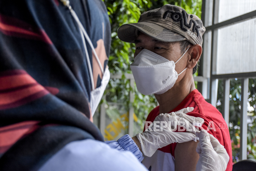 Vaksinator menyuntikkan vaksin Covid-19 dosis ketiga (booster) ke warga di Posko Vaksinasi Covid-19 Terminal Cicaheum, Kota Bandung.