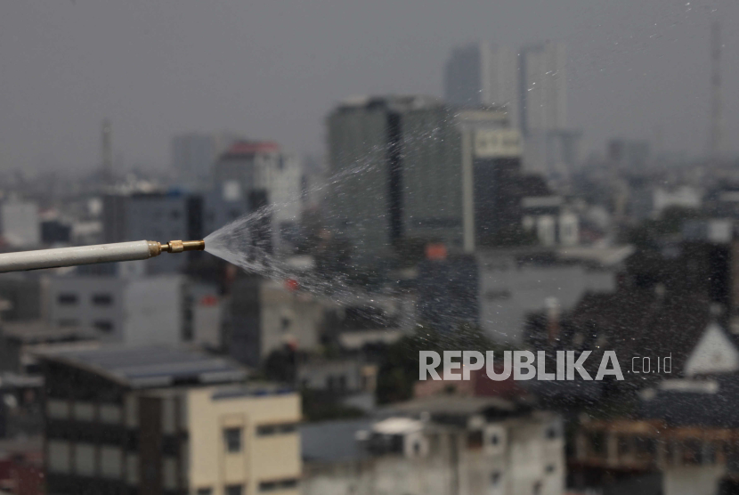 Air yang disemprotkan ke udara di Kantor Wali Kota Jakarta Pusat. Kepala DLH DKI sebut jika polusi udara berstatus darurat bencana ganggu perekonomian.