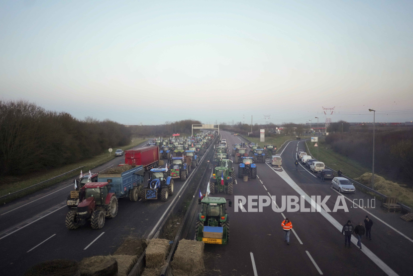 Para petani menduduki jalan raya dengan traktor mereka, di Ourdy, selatan Paris, Rabu, (31/1/2024).