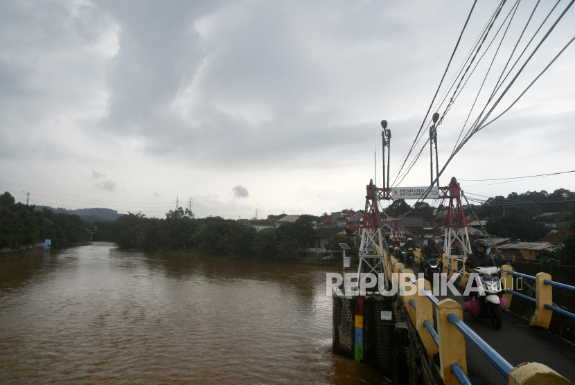 Sejumlah pengendara melintas di jembatan Bendung Katulampa dengan TMA mencapai 30 sentimeter di Kota Bogor, Jawa Barat, Kamis (30/11/2023). Angin muson Asia penanda musim hujan akhirnya tiba.