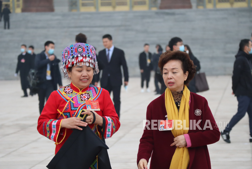 Dua anggota legislatif yang mewakili salah satu kelompok etnis minoritas di China meninggalkan Balai Agung Rakyat, usai mengikuti pembukaan Sidang Tahunan Kongres Rakyat Nasional (NPC) di Beijing,China, Jumat (5/3/2021).