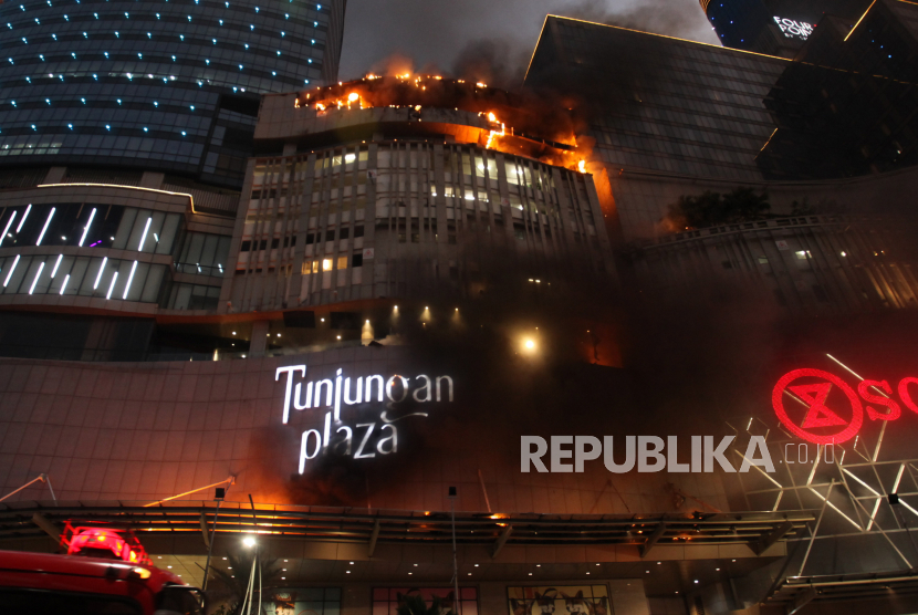 Kobaran api muncul dari Tunjungan Plaza 5 yang terbakar di Surabaya, Jawa Timur, Rabu (13/4/2022). Sejumlah kendaraan pemadam kebakaran dikerahkan termasuk tiga Bronto Skylift untuk memadamkan api yang membakar lantai 5 Tunjungan Plaza 5 itu. 