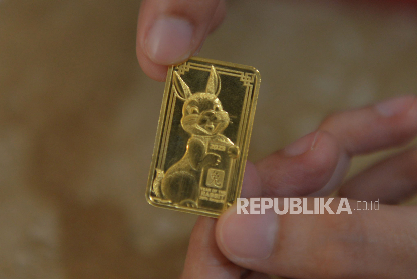 Petugas menunjukan emas batangan edisi Imlek 2023 di Butik Emas Antam, Pulogadung, Jakarta, Senin (16/1/2023). 