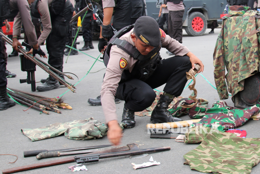 Petugas kepolisian menyita sejumlah atribut dan senjata tajamdi Timika, Papua. (ilustrasi