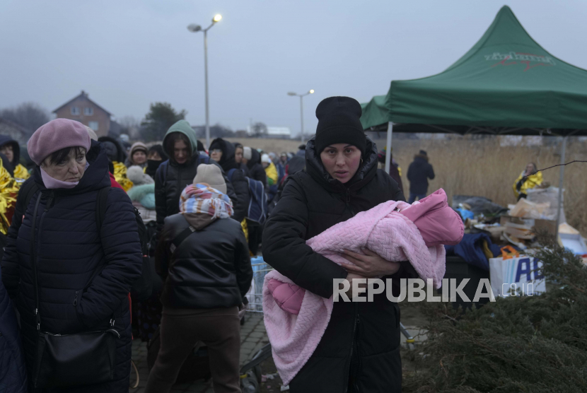 Seorang wanita dengan seorang anak tiba di perbatasan setelah melarikan diri dari Ukraina di Medyka, Polandia, Senin, 7 Maret 2022. 