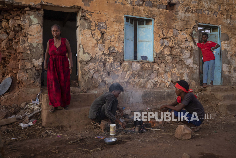  Tigrayans yang melarikan diri dari konflik di wilayah Tigray Ethiopia, menyalakan api kayu untuk menyiapkan makan malam, di depan tempat penampungan sementara mereka di kamp pengungsi Umm Rakouba di Qadarif, Sudan timur, Senin, 7 Desember 2020.