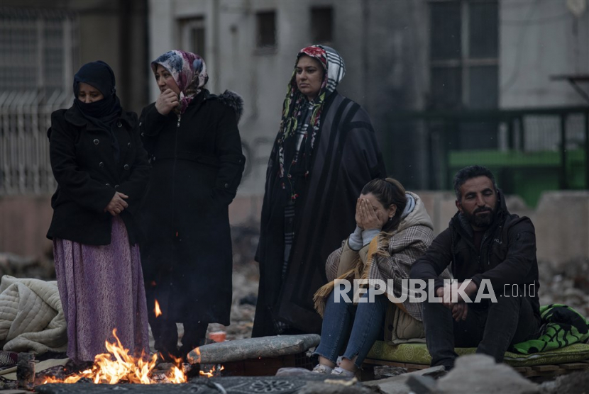  Orang-orang menunggu di samping bangunan yang runtuh setelah gempa kuat di kota Diyarbakir, tenggara Turki, Kamis (9/2/2023). Lebih dari 17.000 orang tewas dan ribuan lainnya luka-luka setelah dua gempa besar melanda Turki selatan dan Suriah utara pada Senin (6/2/2023).