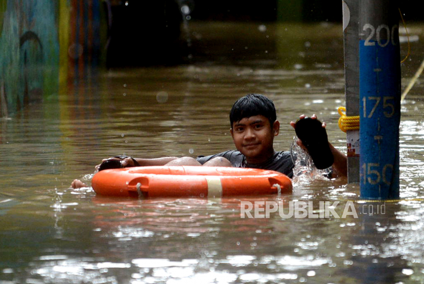 Seorang warga berenang ketika banjir di Kampung Melayu, DKI Jakarta (ilustrasi). BPBD mencatat ada 16 RT di Jakarta yang dilanda banjir hingga Jumat (15/3/2024) pagi.