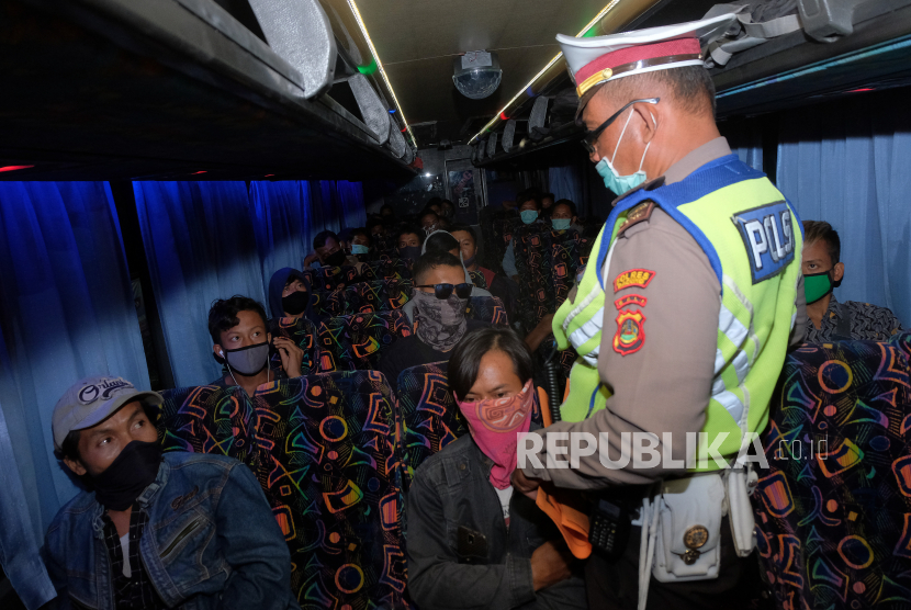 Polisi meminta keterangan dari penumpang bus yang akan mudik saat operasi pengamanan dan penyekatan wabah COVID-19. Ilustrasi.