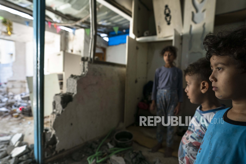 Batul Al-Masri, 5, dan saudara-saudaranya berdiri untuk potret di kamar tidur mereka yang rusak ketika serangan udara menghancurkan sebuah bangunan di dekatnya sebelum gencatan senjata yang menghentikan perang 11 hari antara penguasa Hamas Gaza dan Israel, Rabu, Mei 26, 2021, di Beit Hanoun, Jalur Gaza.