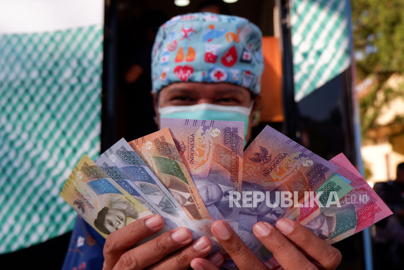 Warga menunjukkan uang rupiah. Bank Indonesia (BI) mengungkapkan likuiditas perekonomian atau uang beredar dalam arti luas pada April 2023 tetap tumbuh positif.
