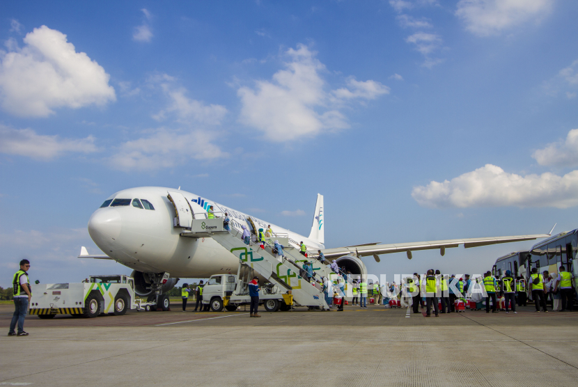 Jamaah calon haji menaiki tangga menuju pesawat di Bandara Syamsudin Noor, Banjarbaru, Kalimantan Selatan, Senin (29/5). Industri penerbangan saat ini tengah dalam proses pulih dari pandemi.