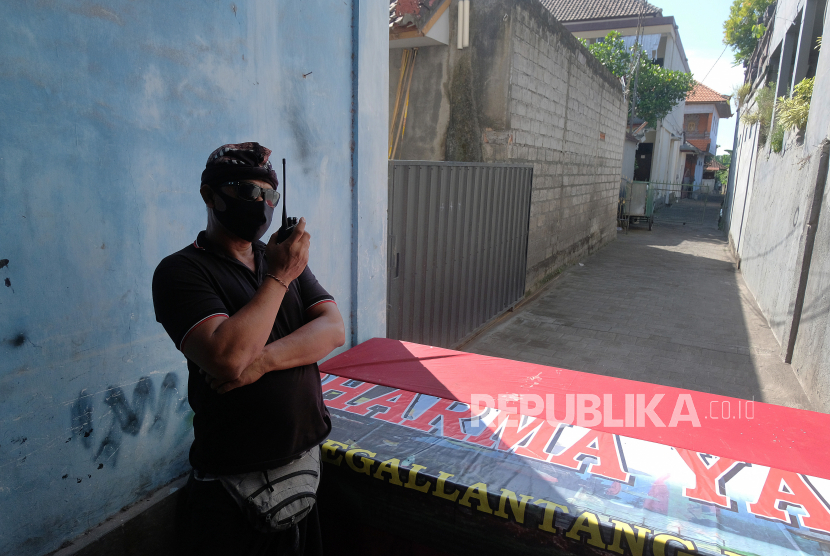 Pecalang atau petugas keamanan adat Bali berkoordinasi menggunakan radio komunikasi saat menjaga kawasan yang diisolasi di Desa Padangsambian Klod, Denpasar, Bali, Selasa (26/5). (ilustrasi)