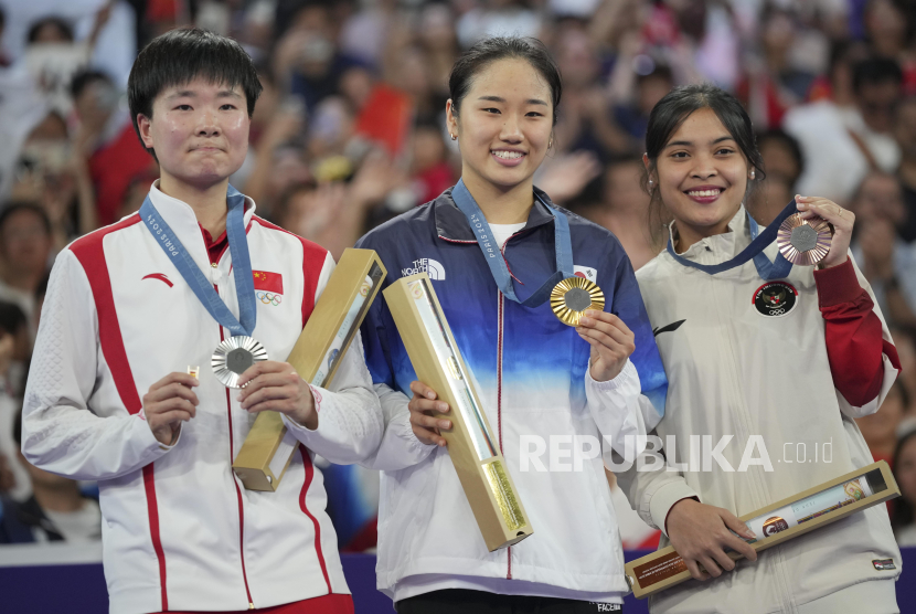 Pebulu tangkis tunggal putri Indonesia Gregoria Mariska Tunjung (kanan) bersama An Se-young (tengah) dan He Bingjiao memperlihatkan medali di Olimpiade Paris, Prancis, Senin (5/8/2024).