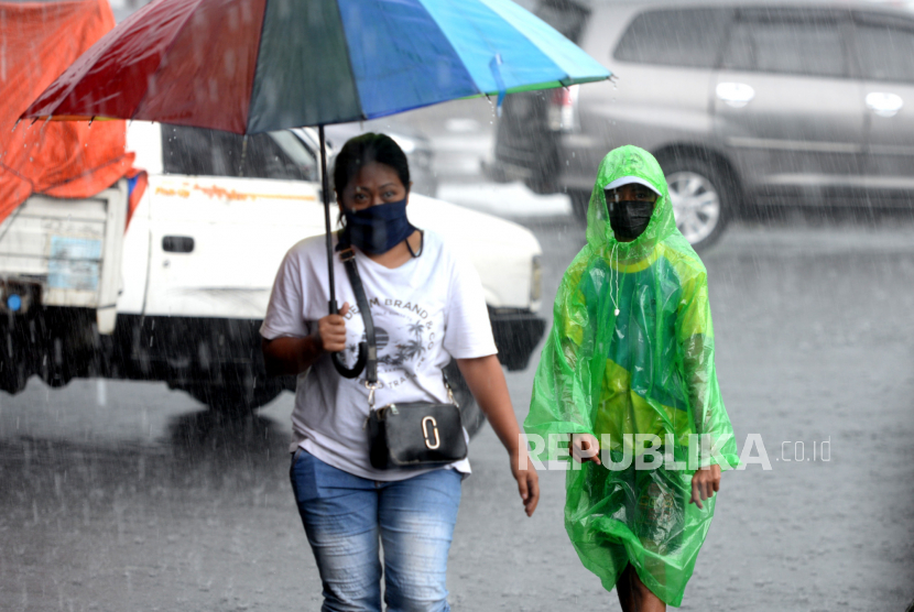 Ojek payung mengawal pelanggan  saat hujan deras di Stasiun Yogyakarta, beberapa waktu lalu.