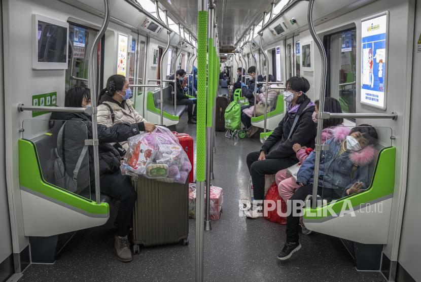 Sejumlah warga mengenakan masker saat menaiki subway di Wuhan, Cina, Senin (30/3). Wuhan, sebagai pusat penyebaran virus Corona, secara perlahan mulai mencabut status lockdown dengan mengizinkan masyarakat untuk memasuki kota setelah lebih dari dua bulan