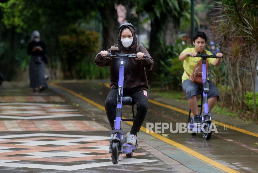Para remaja mengendarai skuter listrik Beam di jalur pedestrian Kebun Raya Bogor, Jawa Barat, Sabtu (24/12/2022). 