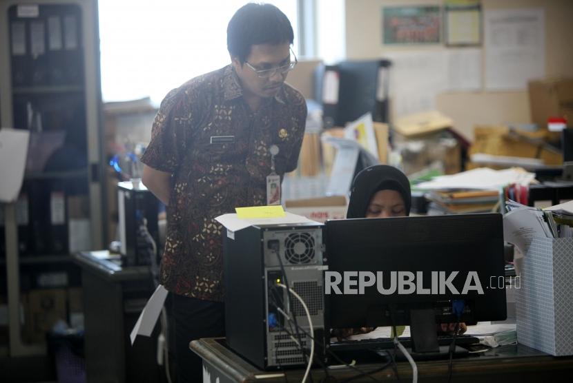 Sejumlah Pegawai Negeri Sipil (PNS) Pemprov DKI Jakarta melakukan aktivitas pada hari pertama masuk kerja usai libur Idul Fitri di Badan Kepegawaian Daerah (BKD) gedung Balaikota, Jakarta, Kamis (21/6).