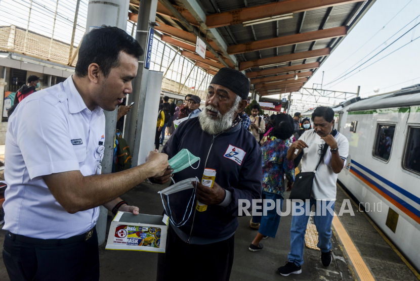 Petugas memberikan masker kepada penumpang di Stasiun Depok, Depok, Jawa Barat, Jumat (6/3).