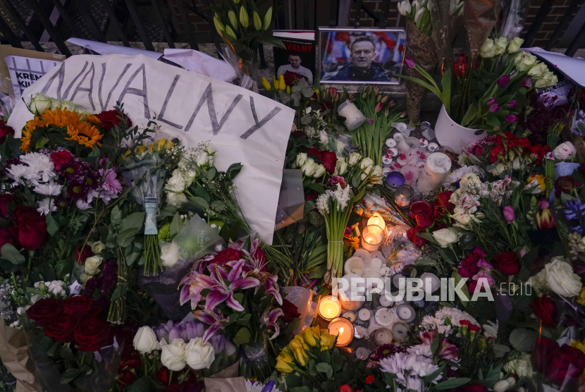 Bunga dan lilin yang menyala ditinggalkan di seberang kedutaan Rusia, untuk memperingati kematian Alexei Navalny di London, Sabtu, (17/2/2024).