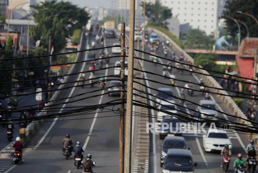 Kabel jaringan utilitas yang melintang di atas jalan protokol di kawasan Palmerah, Jakarta Barat, Jumat (4/8/2023).