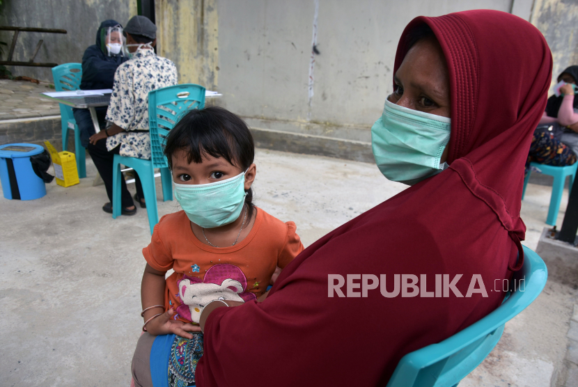 Seorang ibu dan anaknya mengantre untuk menjalani tes cepat (rapid test) COVID-19 di Puskesmas Senapelan, Kota Pekanbaru, Riau, Kamis (2/4/2020). Seluruh Puskesmas di Pekanbaru menggelar rapid test serentak yang diprioritaskan untuk Tenaga Kerja Indonesia (TKI) berstatus Orang Dalam Pemantauan (ODP), karena jumlah jumlah ODP di Provinsi Riau meningkat drastis hingga lebih dari 20
