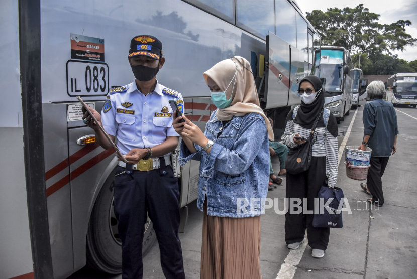 Calon penumpang memindai kode batang melalui aplikasi PeduliLindungi sebelum menaiki bus di Terminal Cicaheum, Kota Bandung, Senin (28/3/2022). Polrestabes Bandung menyiapkan sebanyak 33 pos pengamanan mudik lebaran 2022.
