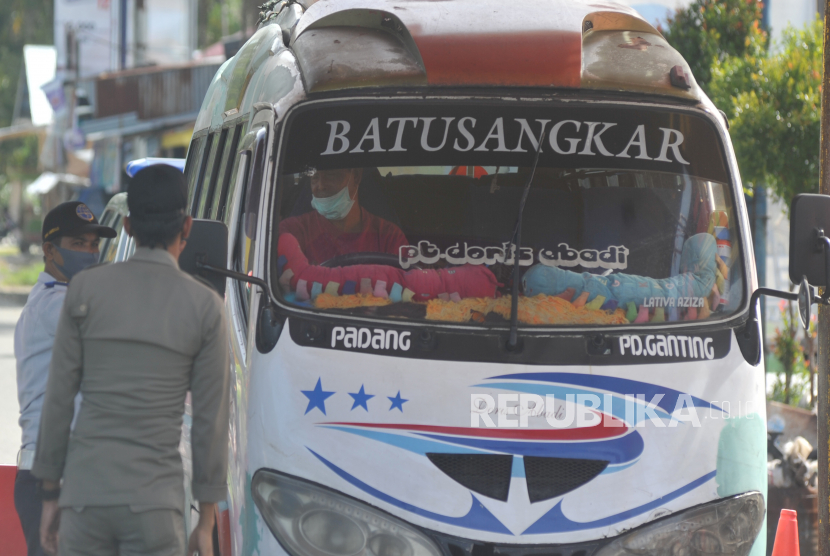 Petugas memeriksa pengendara mobil travel yang masuk kota, di Kayukalek, Padang, Sumatera Barat, Selasa (5/5/2020). Kenaikan harga BBM bersubsidi sudah mulai berdampak kepada sektor angkutan antarkota.