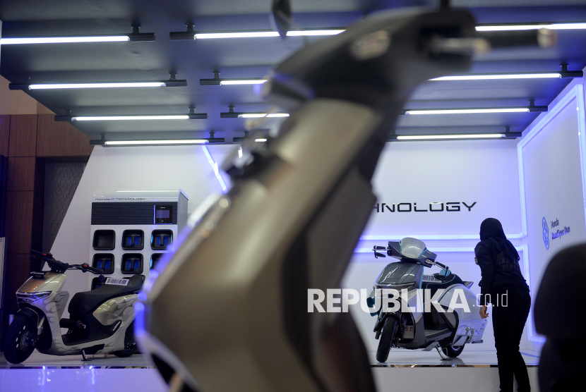 Pengunjung melihat motor listrik yang dipajang di pameran.