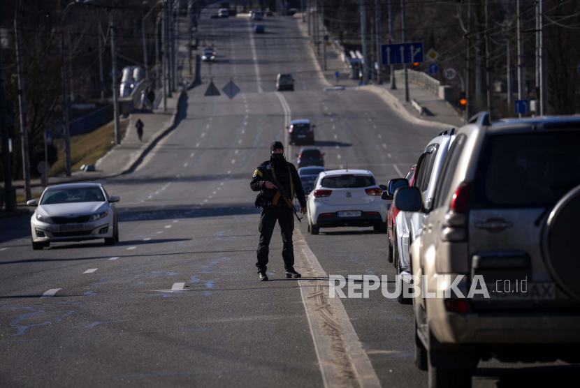 Seorang petugas polisi berjaga di jalan menuju pusat Kyiv, Ukraina, Senin, 28 Februari 2022.