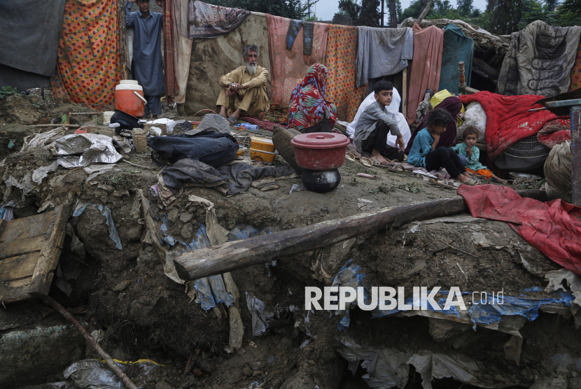 Penduduk desa Mateen Khan duduk di atas reruntuhan rumah mereka yang rusak akibat banjir bandang di lingkungan Pir Baba, wilayah distrik Buner, Pakistan, Ahad (17/8/2025).